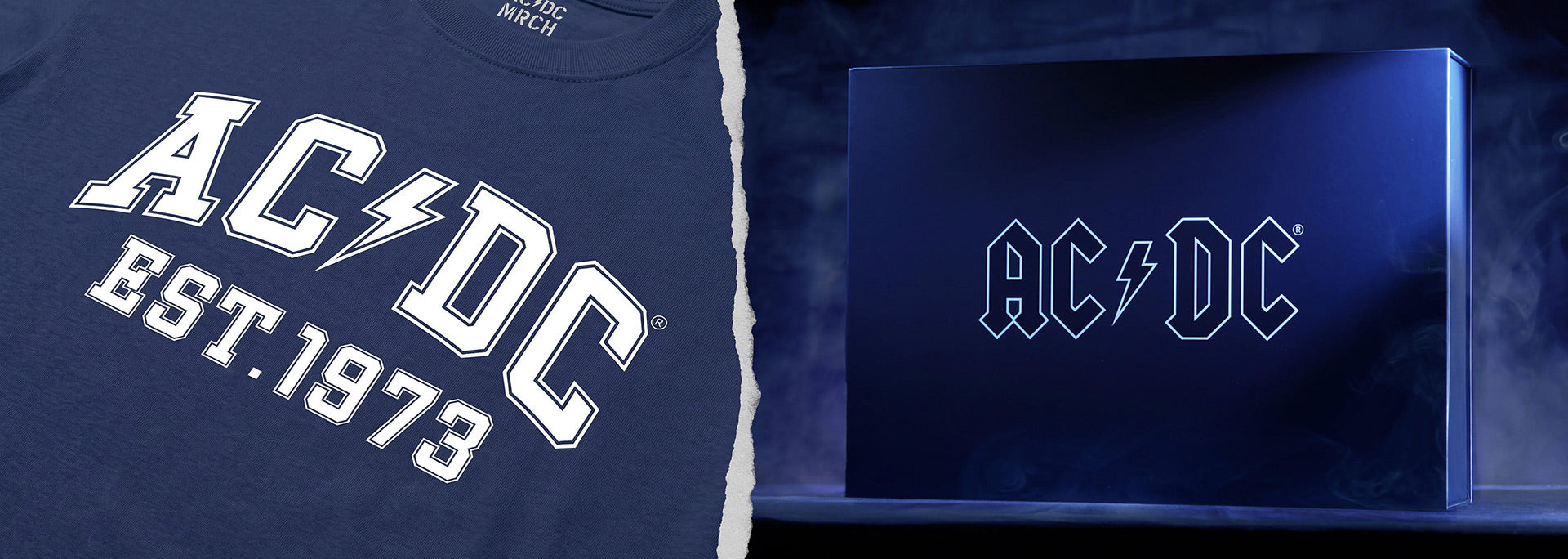 Shop the Rock 101 collection. A navy blue AC/DC graphic t-shirt shown alongside a matching navy blue AC/DC branded box or plaque, both featuring the band's logo and 'EST. 1973' text.